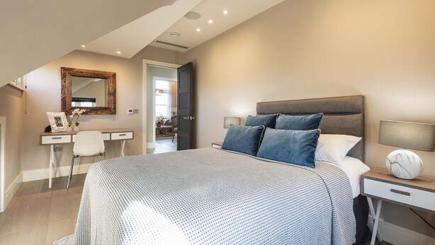 A bedroom with a large bed, a desk, a chair, a mirror, and a nightstand with a lamp. - Hampstead Lux Flat-Hosted by Sweetstay (London)