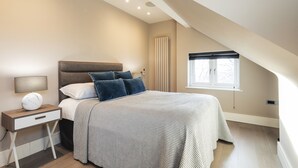 A bedroom with a bed, bedside table, lamp, and window. - Hampstead Lux Flat-Hosted by Sweetstay (London)