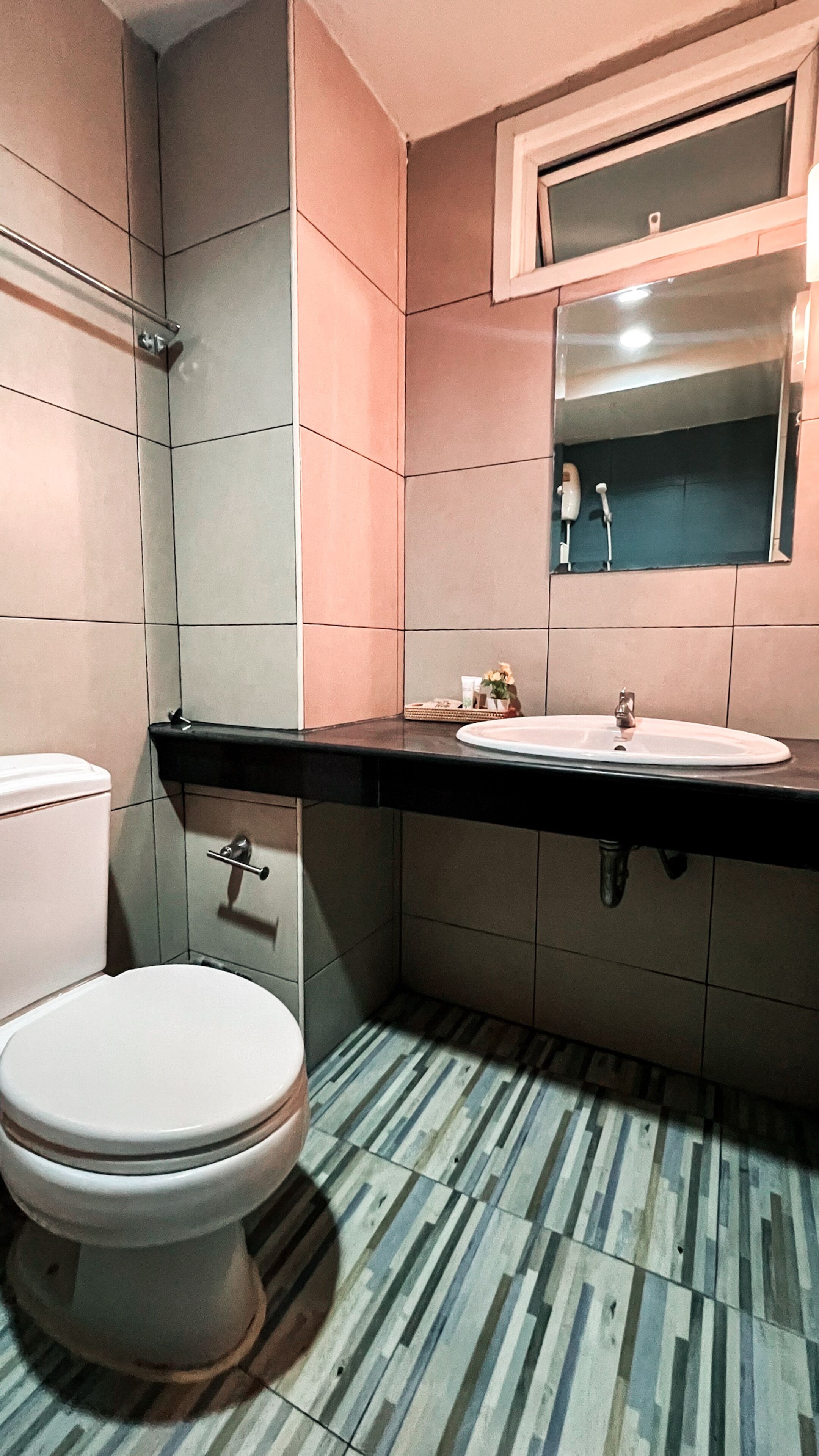 A bathroom with a toilet, sink, and shower.