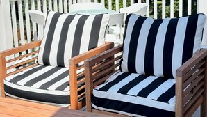 A wooden deck with two striped cushioned chairs and a small table. - 2 Bedroom/2 Bath In the Heart of Newport- Deck + Back Yard + Off-Street Parking! (Newport)