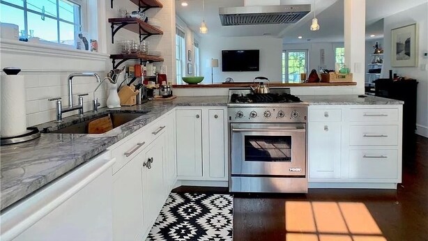 A modern kitchen with white cabinetry, a gas stove, an oven, and a large window. - 2 Bedroom/2 Bath In the Heart of Newport- Deck + Back Yard + Off-Street Parking! (Newport)