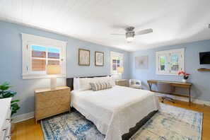 A bedroom with a bed, bedside tables, a desk, and a chair. - Silver Palms - Holiday in Style: Beach + Pool! (St. Augustine Beach)