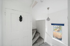 Stairs lead to an upper level from this well-maintained space with a door and window offering a view of the outdoors.