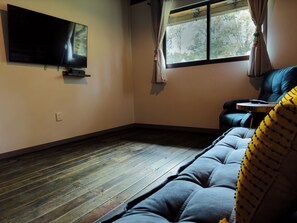 Cabaña familiar | Área de sala de estar | Smart TV de 55 pulgadas con canales digitales, chimenea y Netflix 
