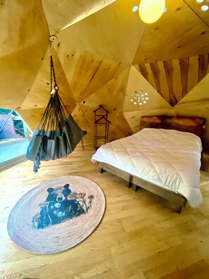 A cozy room with a bed, a hanging chair, and a circular rug. - Ala Glamping (Mudurnu)