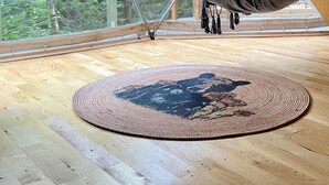 A wooden floor with a hanging black bag and a woven rug. - Ala Glamping (Mudurnu)