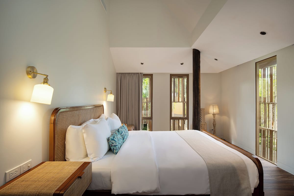 Un dormitorio amplio con una cama grande, dos lámparas de noche y vistas por la ventana.