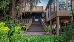 A multi-story building with a wooden staircase leading to a balcony. - Syama Residence (Ayutthaya)