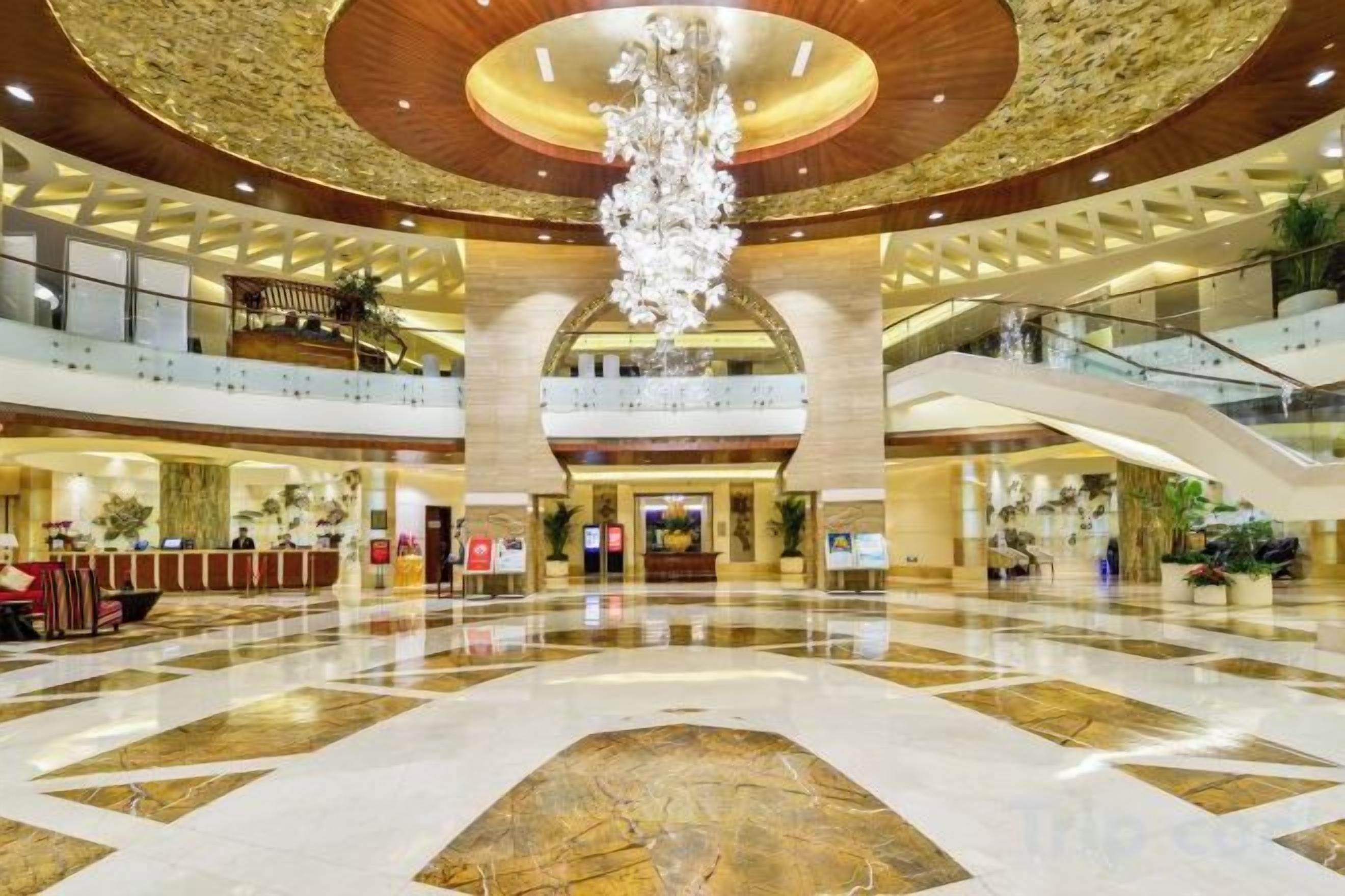 A spacious lobby with a grand chandelier, multiple levels, and a central atrium.