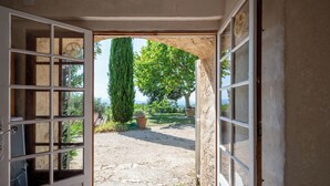 An open doorway leading to a courtyard with a view of a tree and a potted plant. - Domaine Clément Sainte Victoire, 7ha of tranquility 17 km from Aix (Puyloubier)