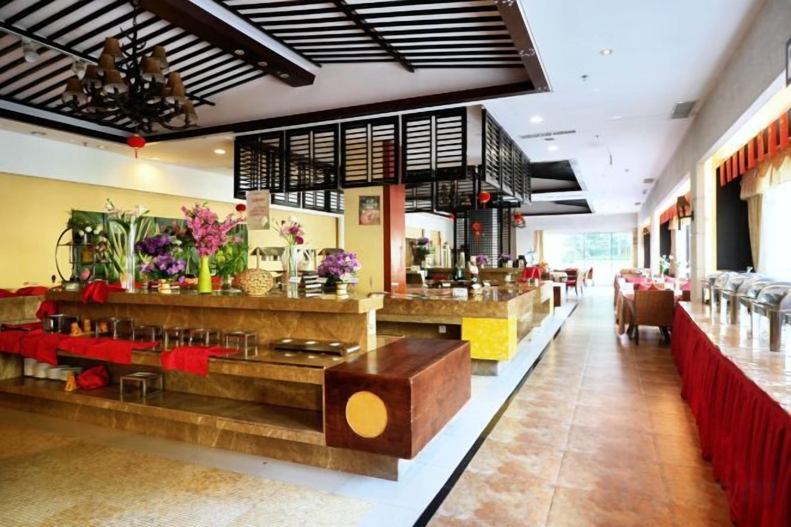 A hotel lobby with a reception desk, seating area, and a staircase leading to an upper level.