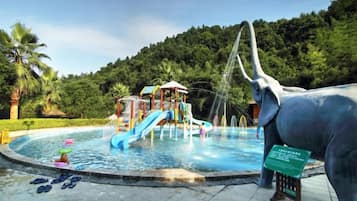 A water park with a slide, a play structure, and a large elephant statue.