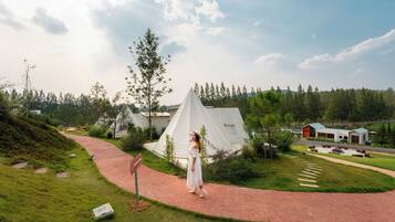 A campsite with tents, a paved path, and a grassy area.