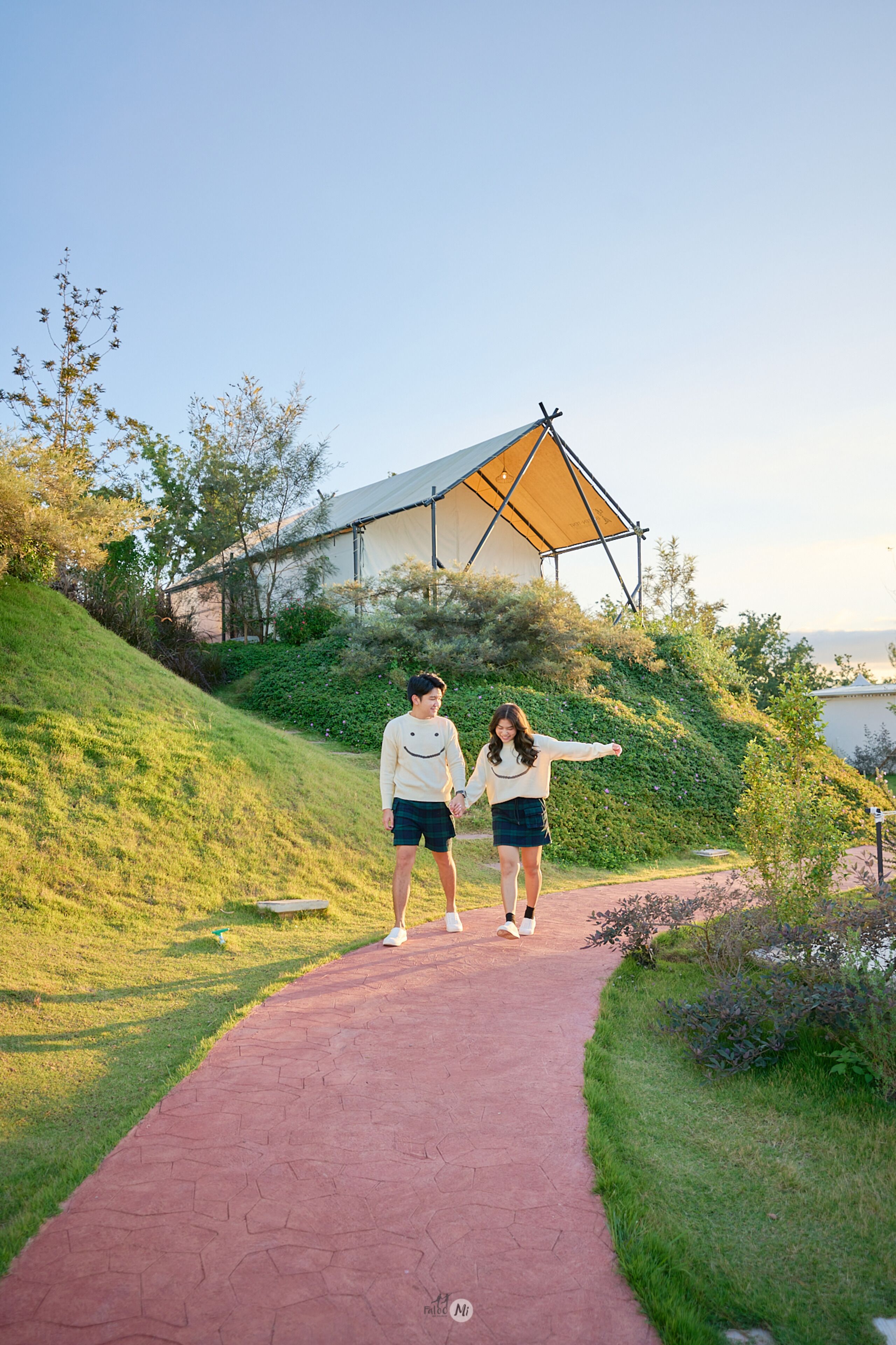 Un sendero que lleva a un edificio con un amplio toldo triangular.