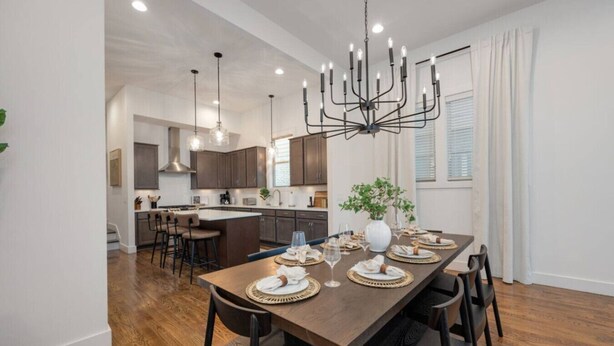 A modern kitchen with dark cabinets, a central island, and pendant lighting. - West End- Best for Families, Work & College Visits (Nashville)