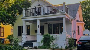 A two-story house with a balcony, a front porch, and a visible mailbox.