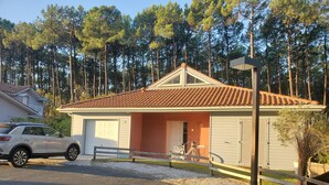 Ein eingeschossiges Haus mit Ziegeldach, Garage und Veranda.
