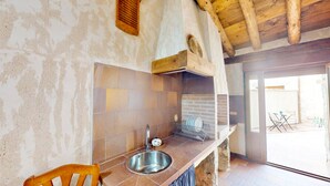 Una cocina con un lavamanos, una silla de madera y un salpicadero de azulejos.