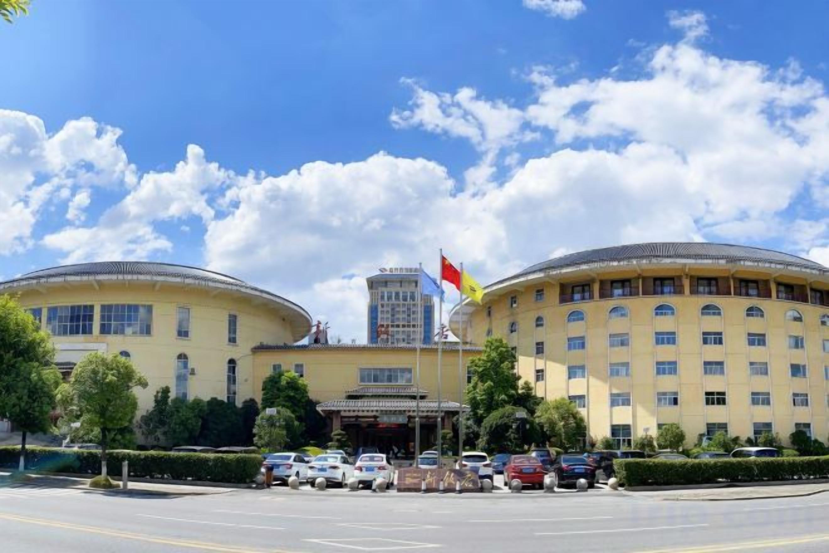 A large, yellow building with a central entrance and two round structures on either side.