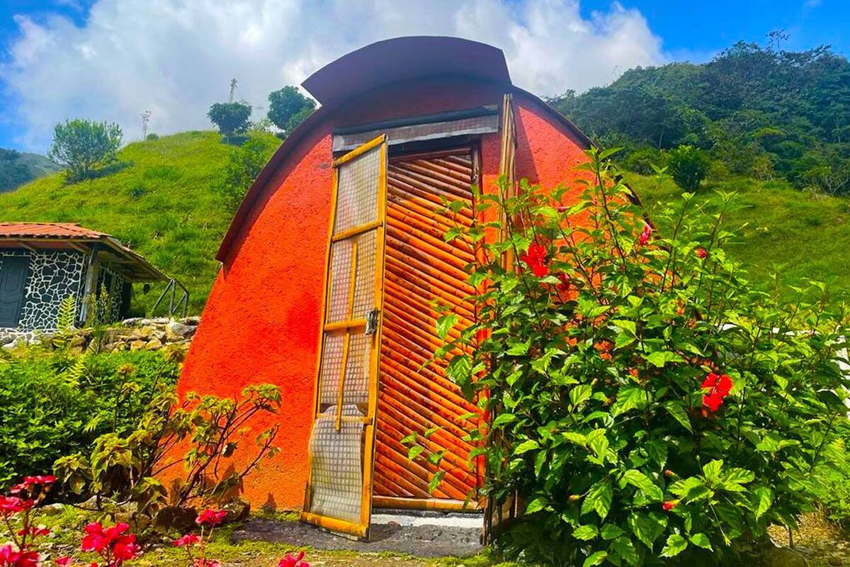 A circular building with a red exterior and a wooden door.