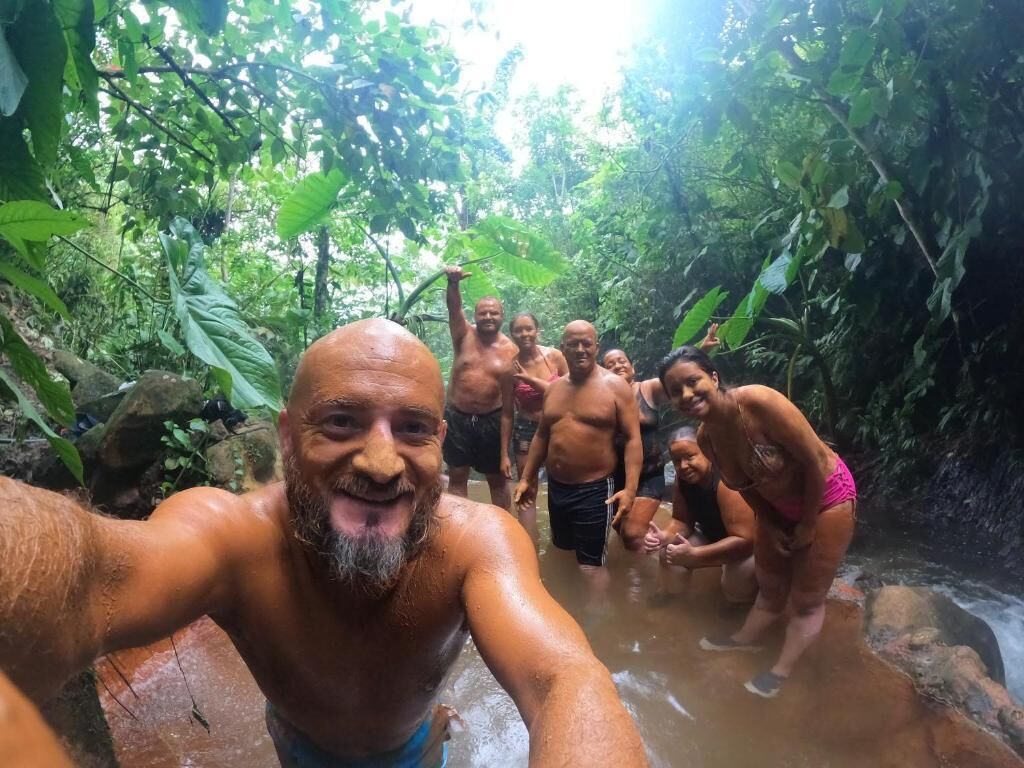 Un groupe de personnes se trouve dans un environnement naturel, au milieu d’une végétation luxuriante.