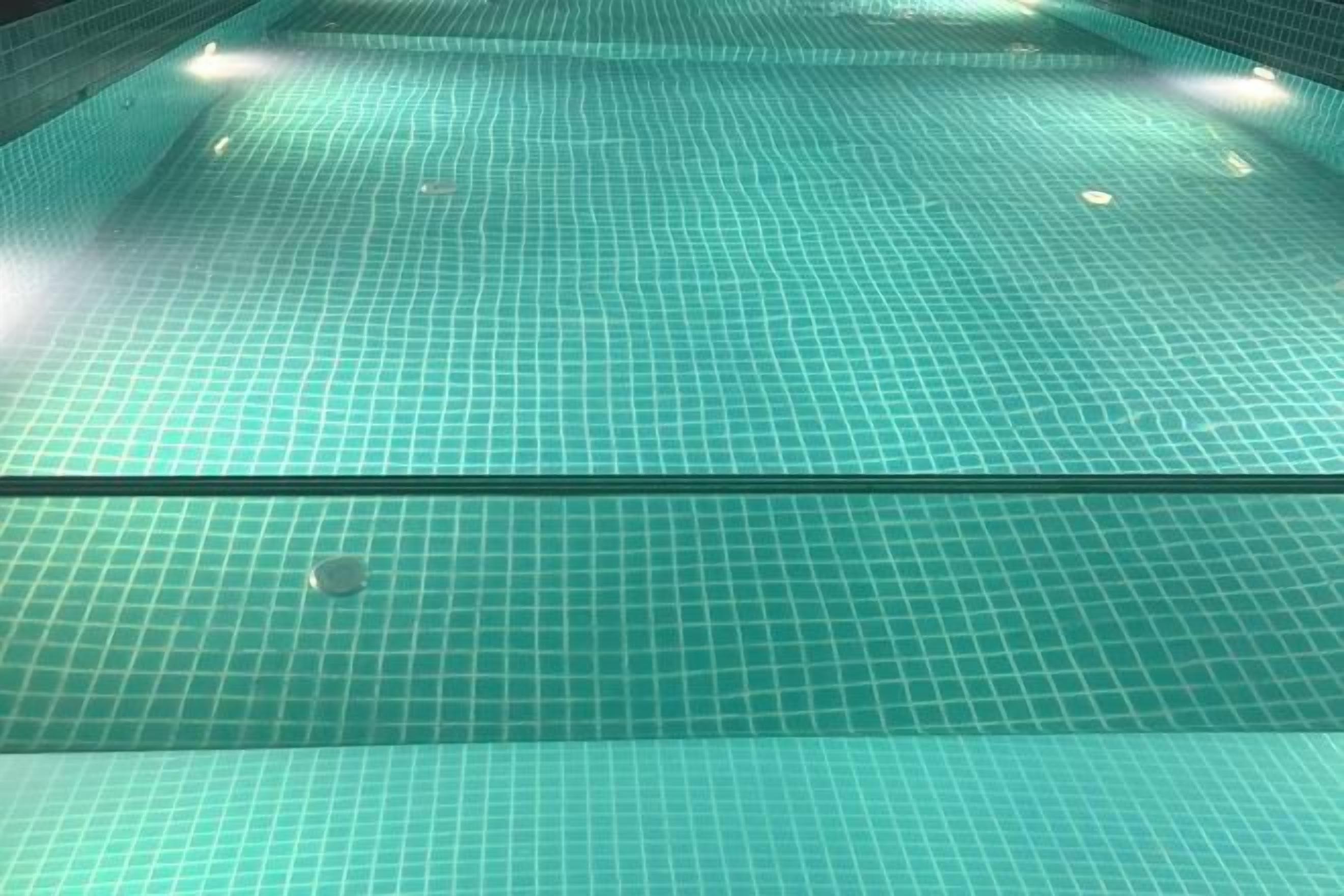 A tiled pool with a grid pattern and a clear bottom.