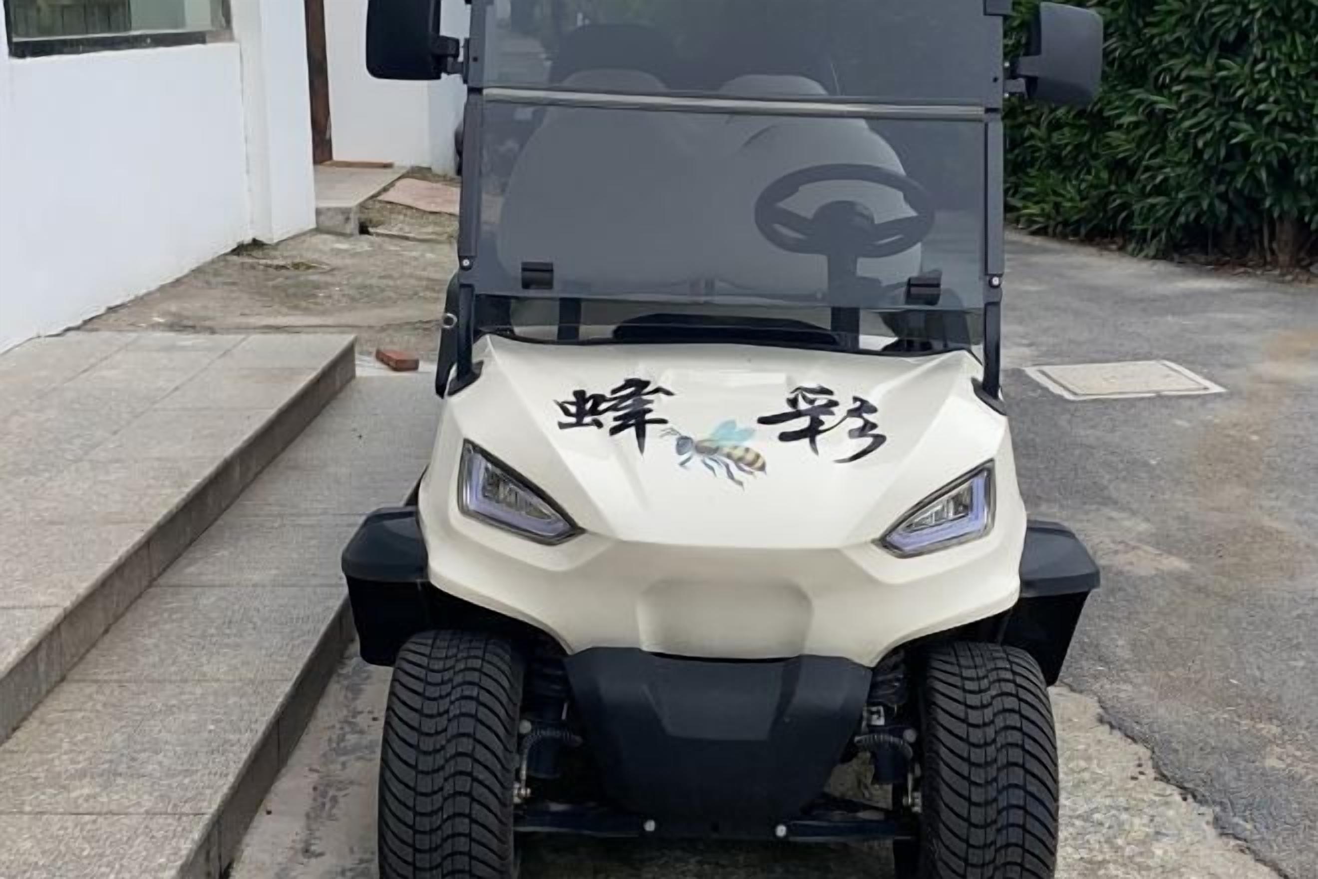 A golf cart with a white body and black tires parked on a concrete surface.