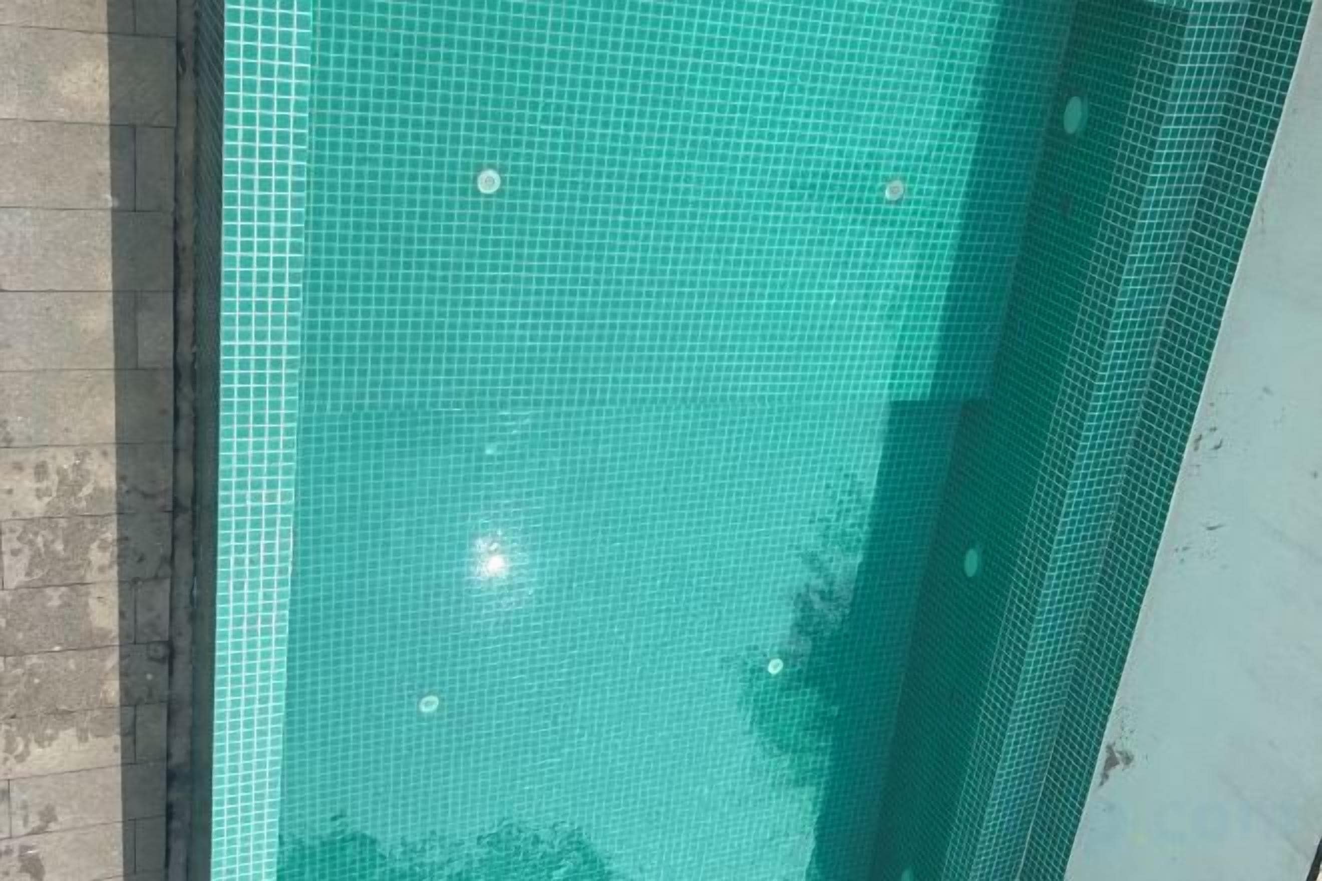 Una piscina con superficie de azulejos y borde visible.
