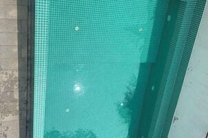 Una piscina con superficie de azulejos y borde visible.