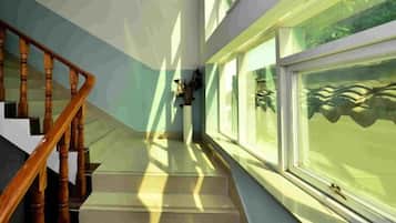 A staircase with wooden handrails leading to a landing with a window.