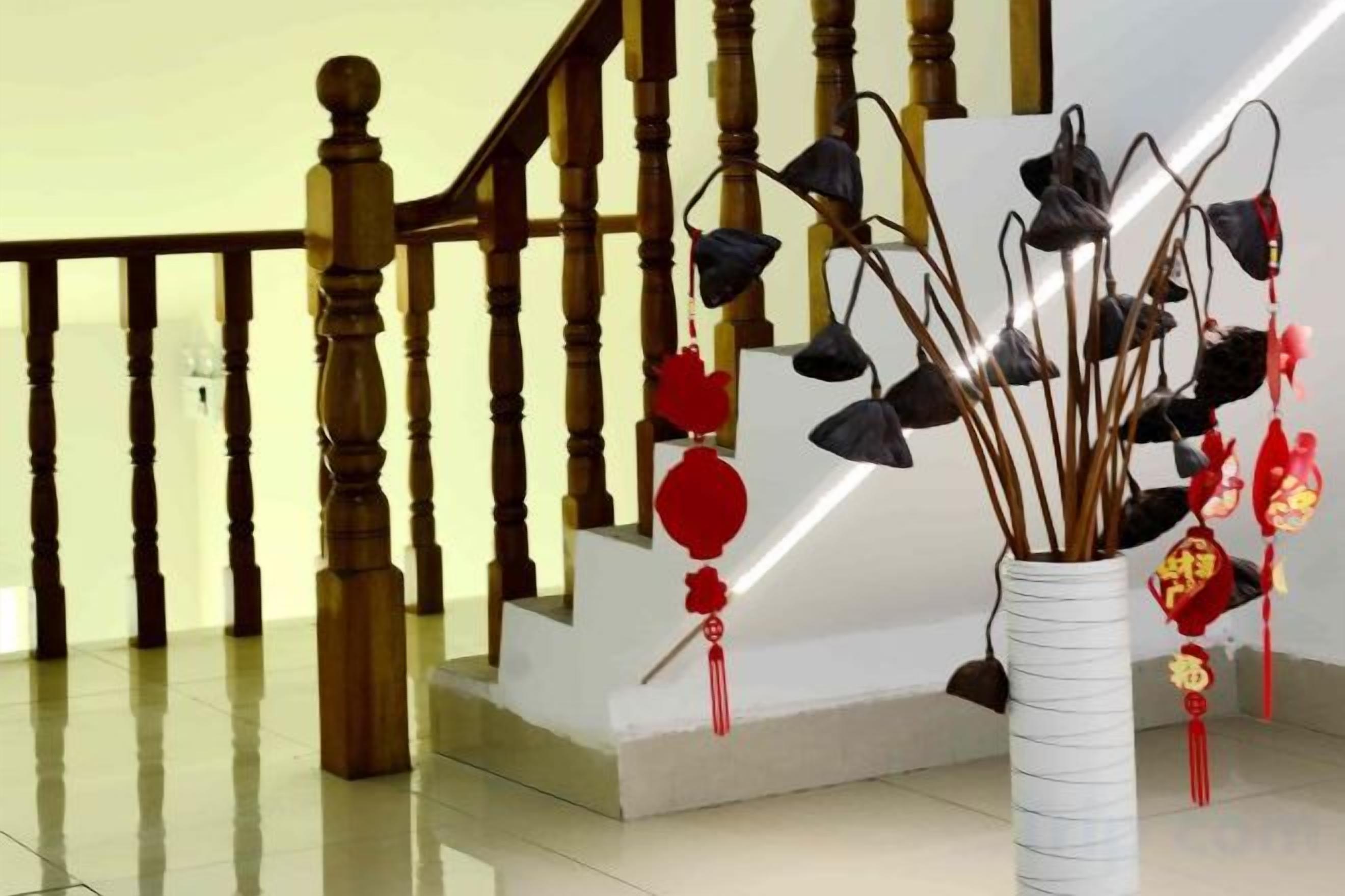 A staircase with wooden balusters and a white vase with hanging ornaments.