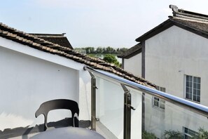 Een klassiek gebouw met een pannendak en een moderne glazen balustrade.