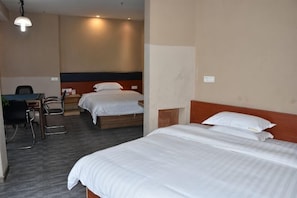 A hotel room with two beds, a desk, and a chair.