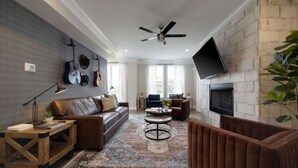 A modern living room with a sofa, armchairs, a coffee table, and a fireplace.