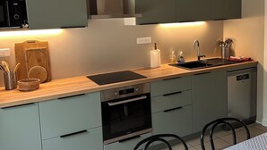 Eine moderne Küche mit Einbauofen, Spüle und Essbereich mit Tisch und Stühlen.