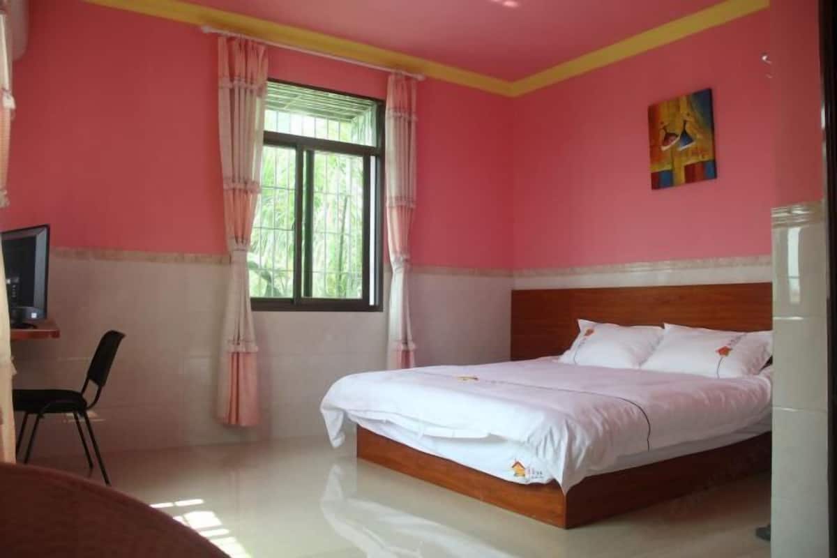 A bedroom with a bed, a desk, and a chair.