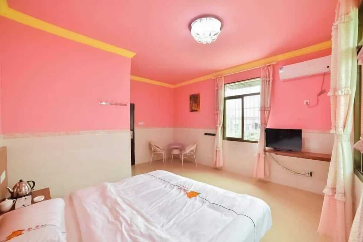 A hotel room with a bed, a desk, a chair, a television, and a window with curtains.