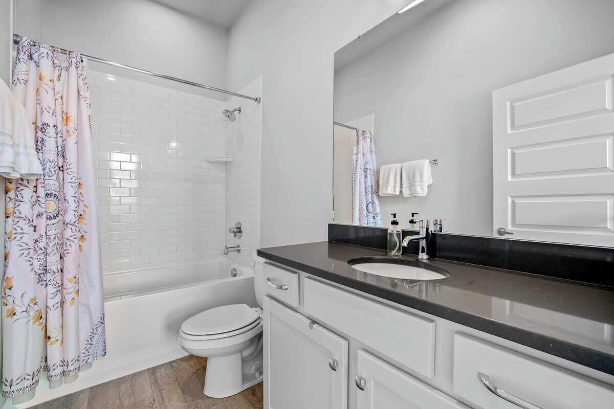 A modern bathroom with a shower, toilet, and vanity.