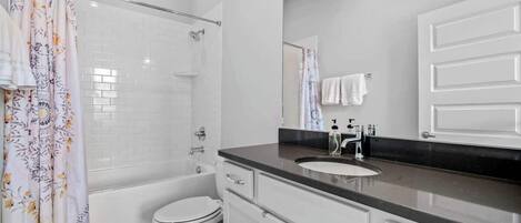 A modern bathroom with a shower, toilet, and vanity.