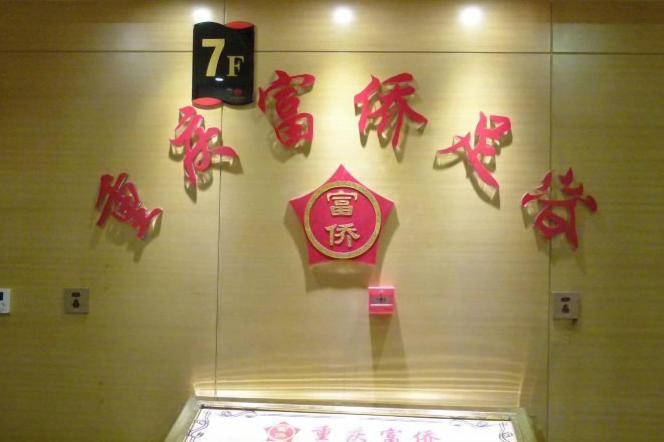 A hotel room with a number sign, decorative wall elements, and a framed item on the wall.
