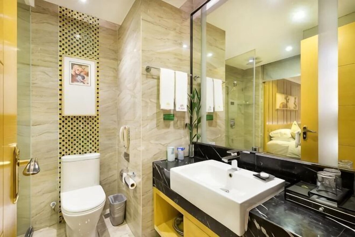 A modern bathroom with a toilet, sink, and shower.