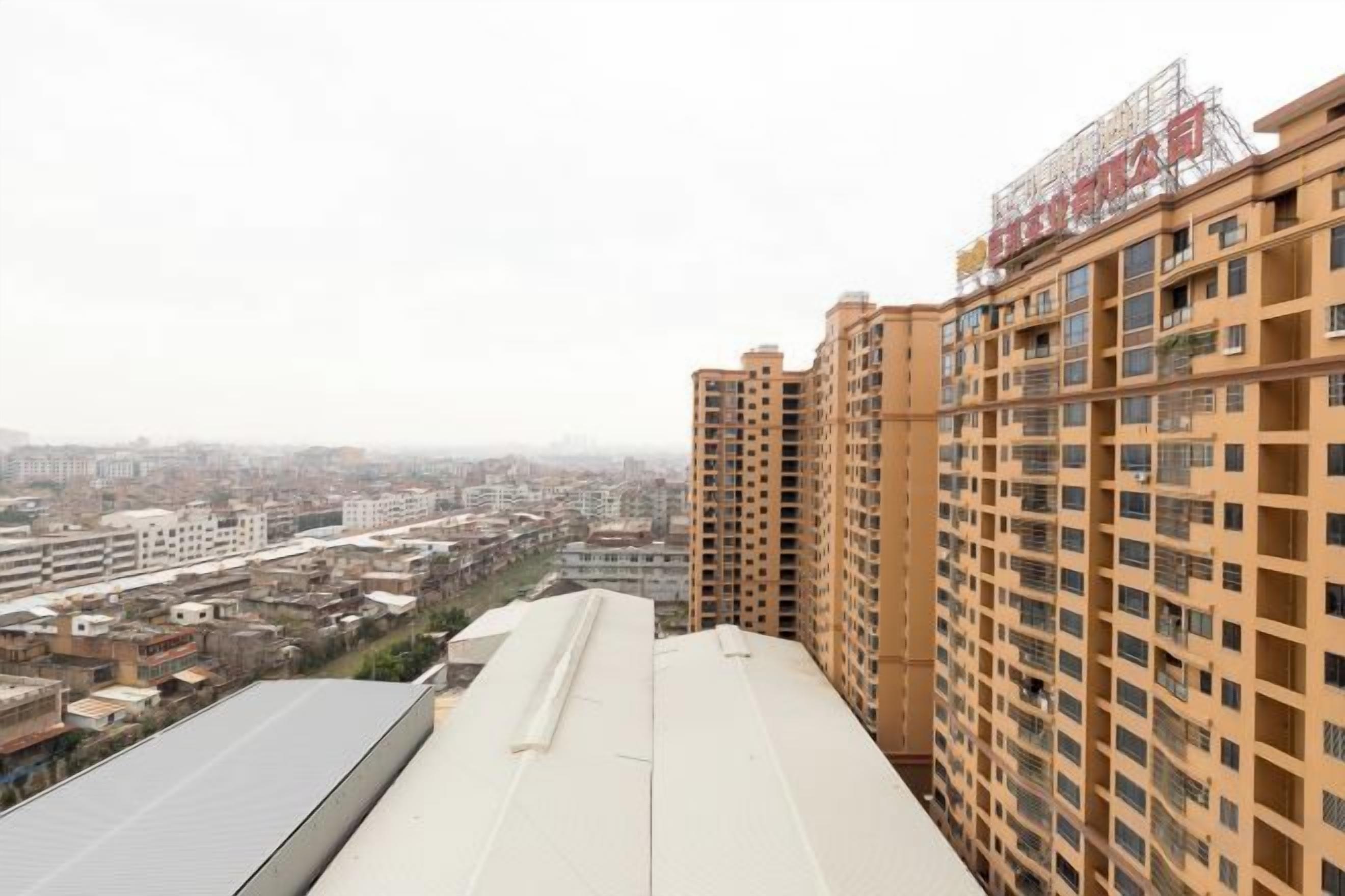 Un edificio alto con varios pisos y techo plano.