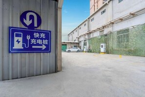 A parking area with a sign indicating a charging station. - Jukai International Hotel (Nan'an)