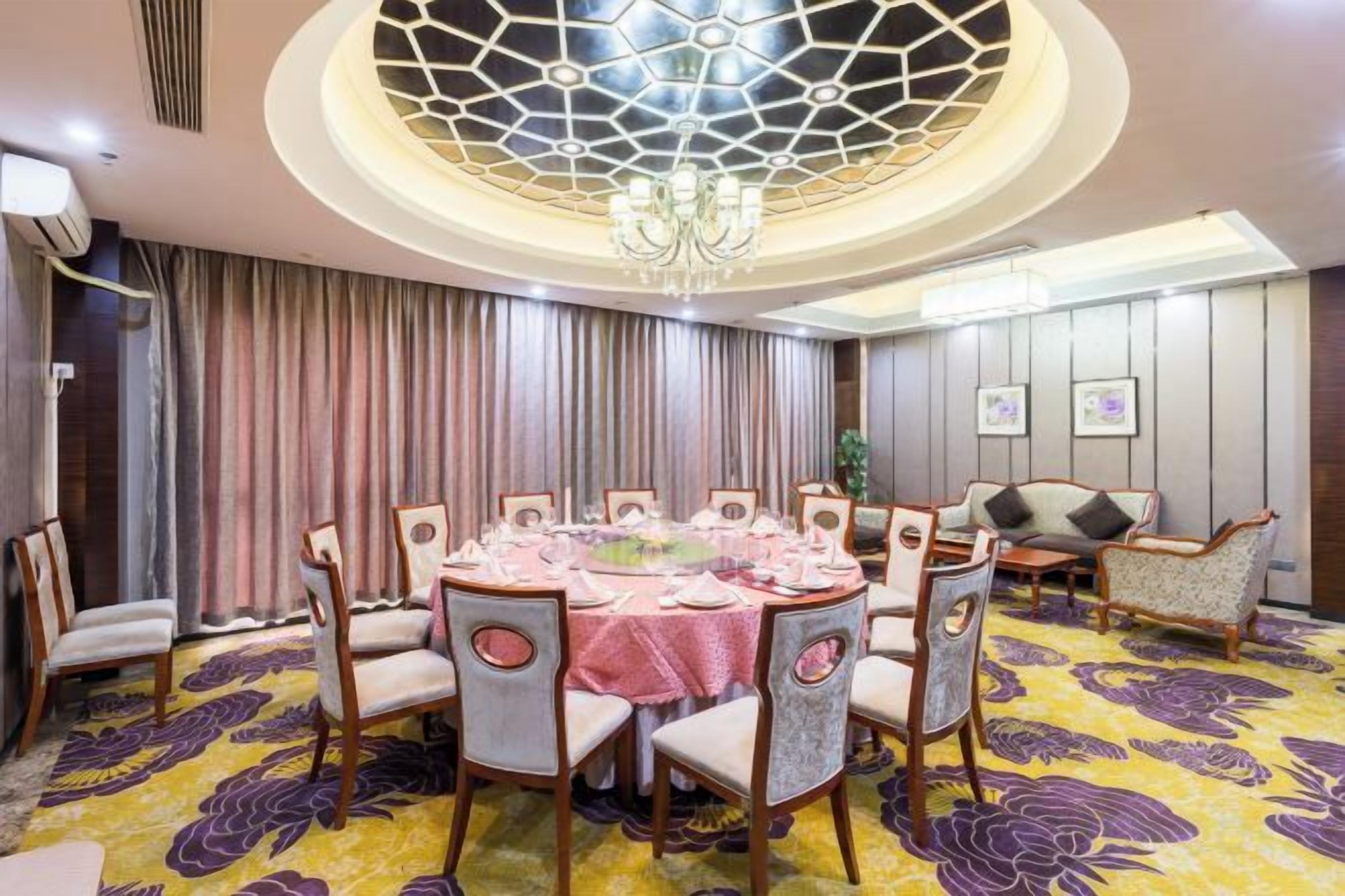 Un comedor con una mesa redonda dispuesta para seis personas, rodeada de sillas con asientos acolchados.