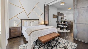 Une chambre à coucher avec un lit, une table de chevet et un banc.