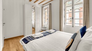 A bedroom with a bed, a window, and a door. - Frère Jacques - Appt situé plein centre (Toulouse)