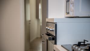 Een moderne keuken met roestvrijstalen apparatuur, een magnetron en een gasfornuis.