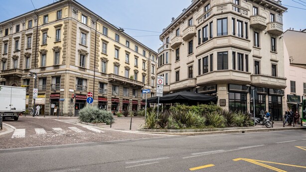 Straatbeeld met een gebouw dat een restaurant herbergt en een bord waarop staat dat parkeren niet toegestaan is.