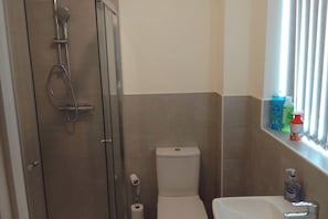 Ein Badezimmer mit Dusche, Toilette und Waschbecken.