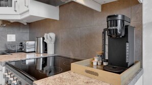 Cocina moderna con Keurig integrado, estufa y encimera con estación para café.